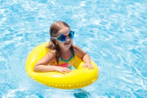 Child,With,Inflatable,Ring,In,Swimming,Pool.,Little,Girl,With